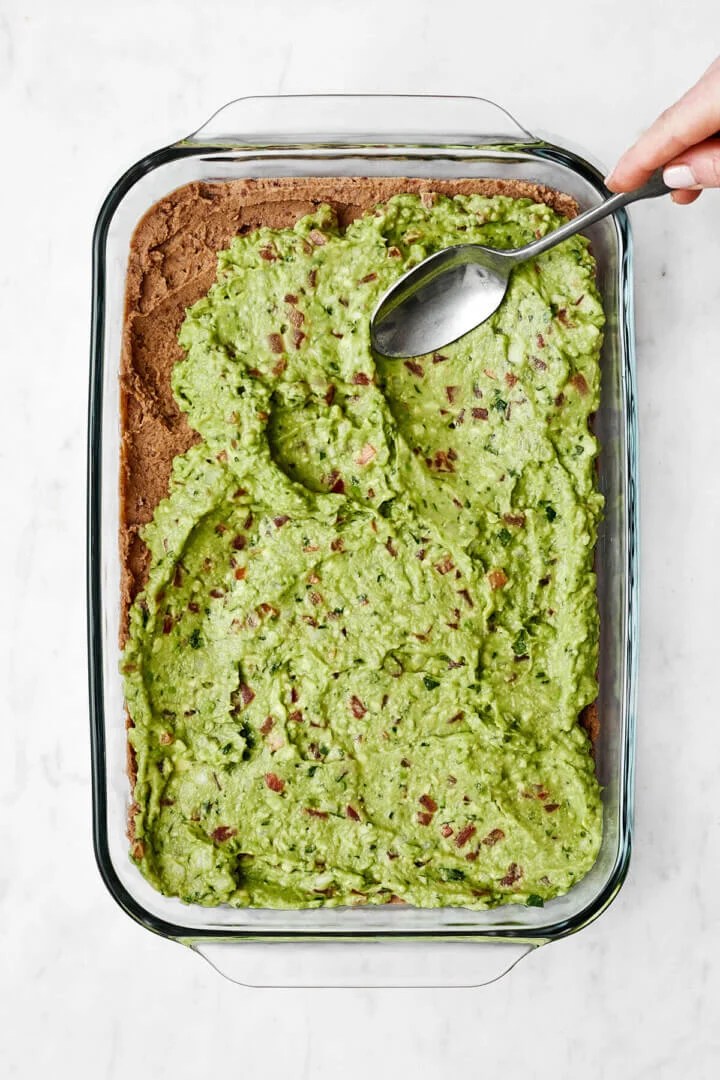 Adding a layer of guacamole for 7 layer dip