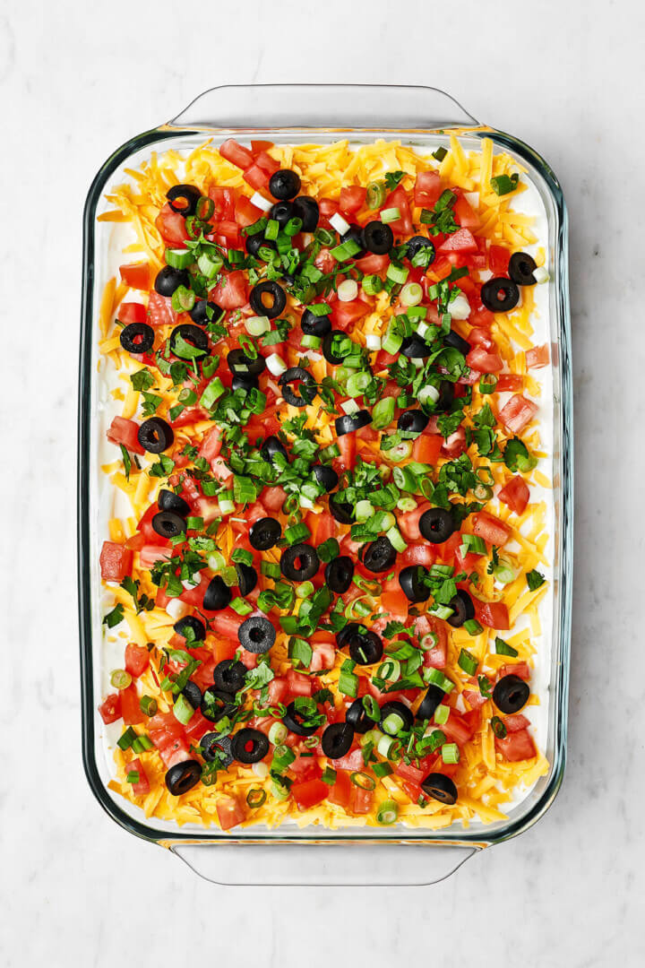 A clear baking dish with 7 layer dip