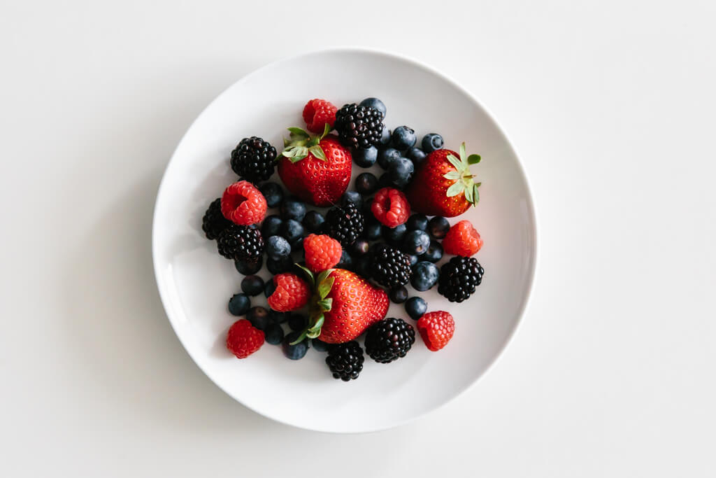 Plate of berries on a white table.