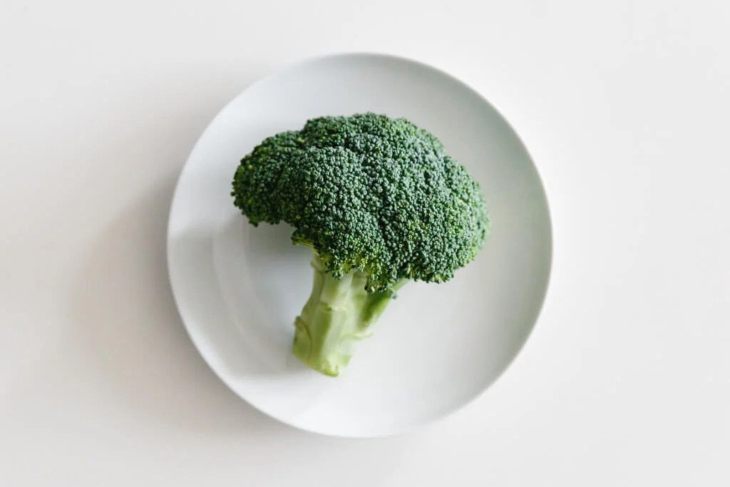 Plate of broccoli on a white table. 