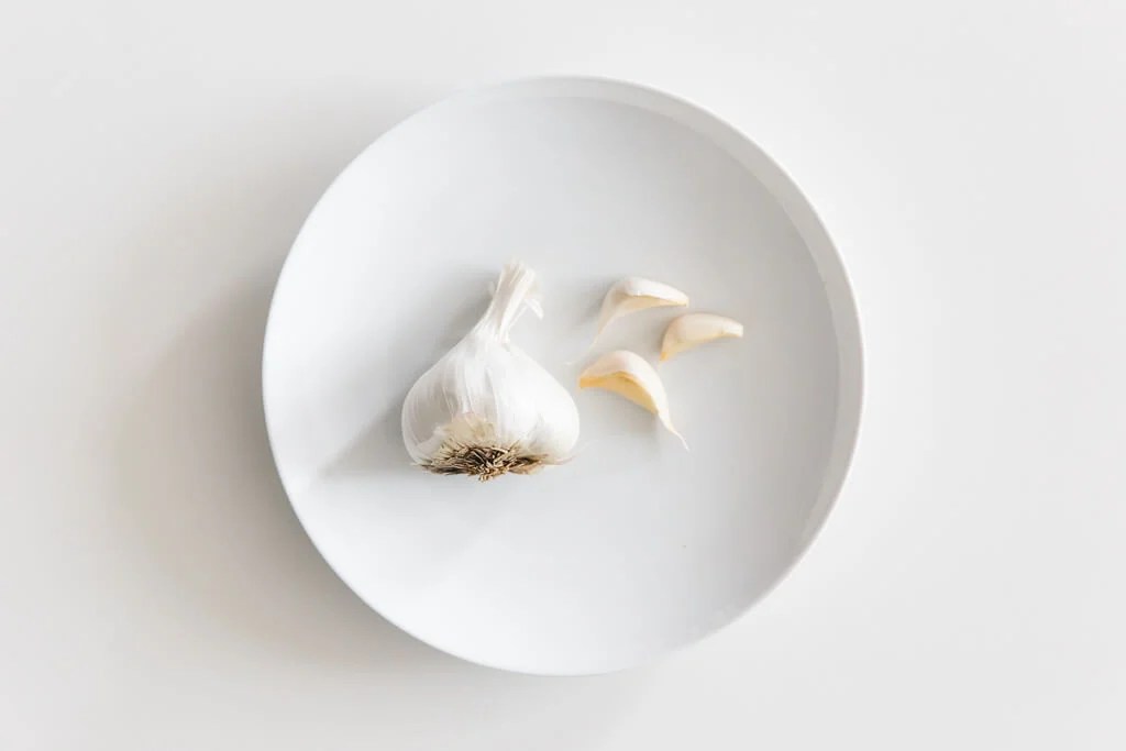 Plate of garlic on a white table. 