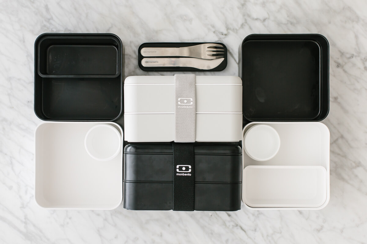 Black and white bento box containers on a countertop.