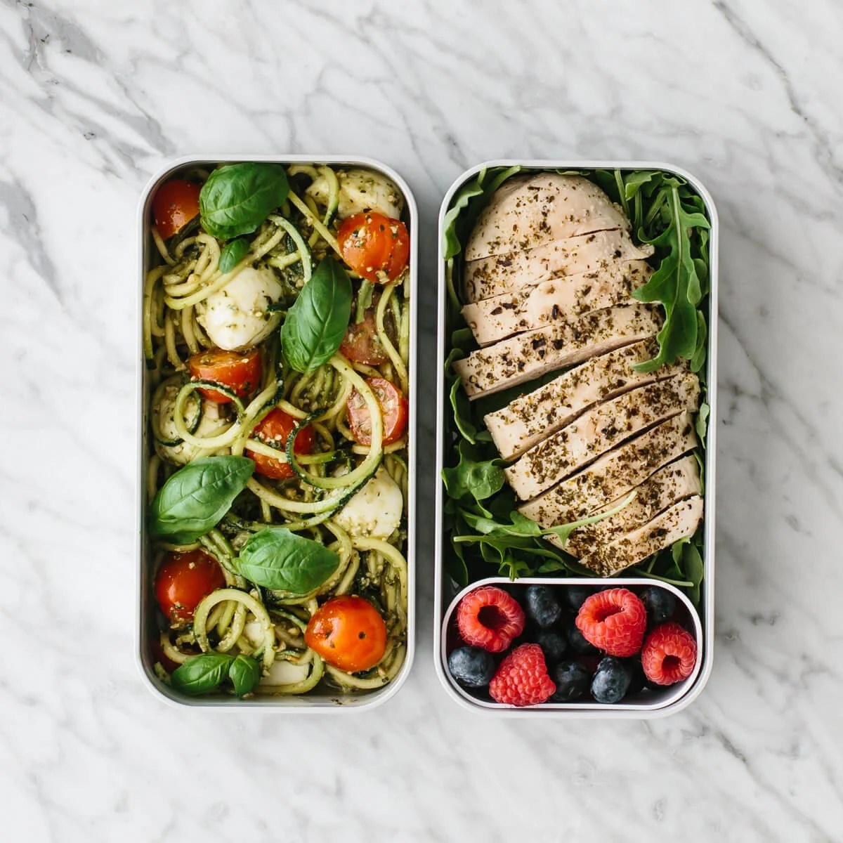 Bento box filled with zucchini noodles, chicken and berries.