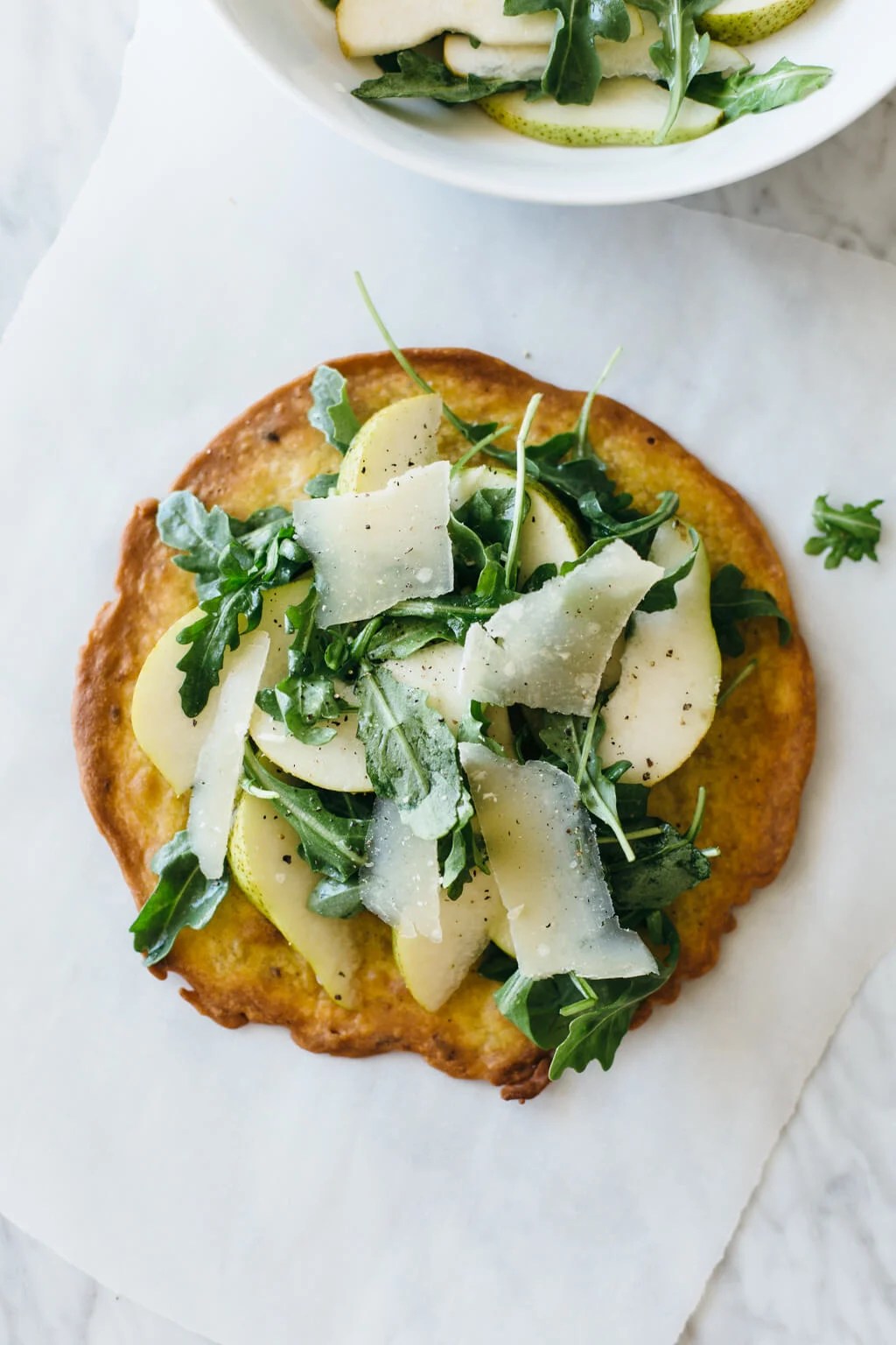 (gluten-free, grain-free) Crispy socca with pear and arugula salad. Made with chickpea flour, this crispy socca becomes the perfect base for a delicious and healthy salad.
