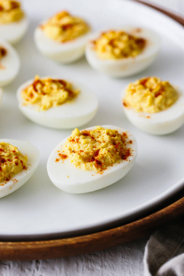 Deviled eggs are hard boiled eggs where the yolk is mixed with mayonnaise, mustard, vinegar, salt and pepper. A little sprinkle of paprika on top helps make these the best deviled eggs recipe.