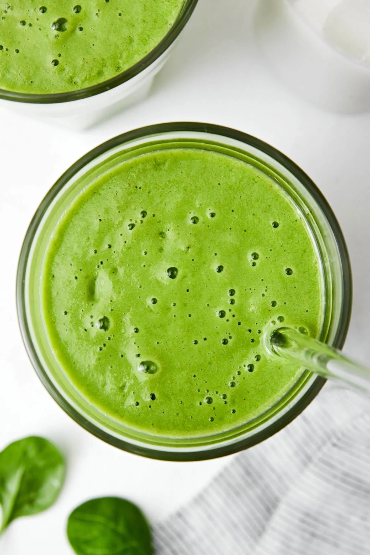 Green smoothie in a cup with a straw.