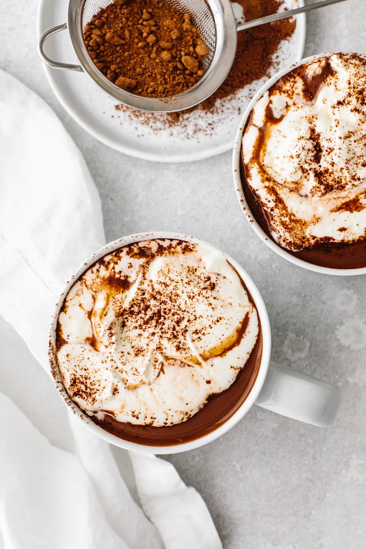 Mugs of hot chocolate with cream.