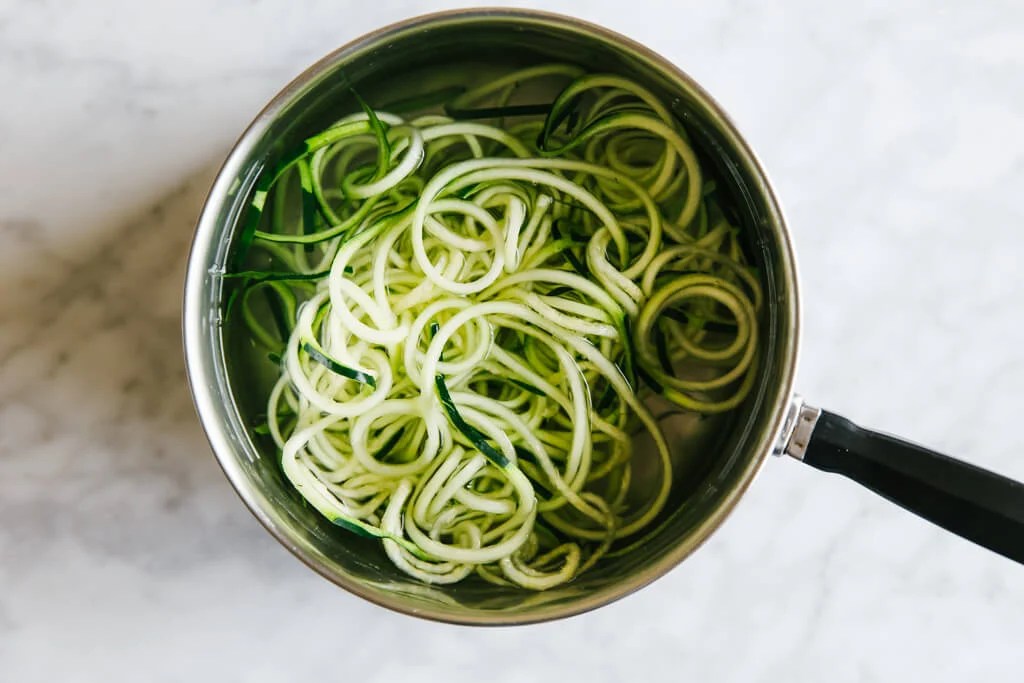 Zucchini noodles in a pot with water.