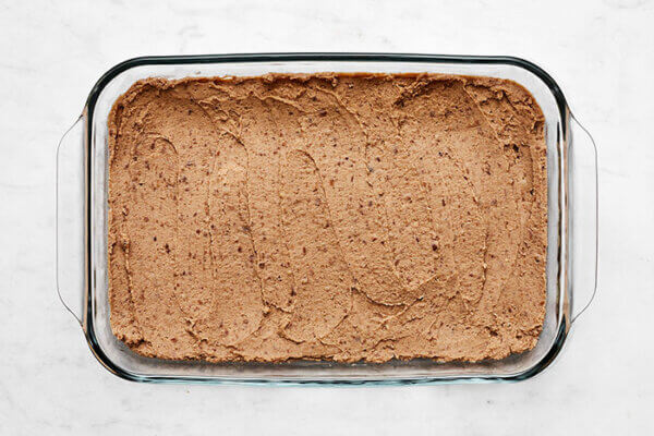 Refried beans in a baking dish for 7 layer dip