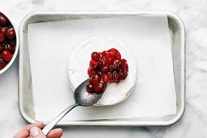Brie on a sheet pan with cranberry sauce.