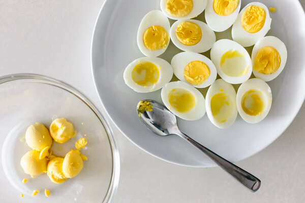 Scooping the yolk out of the hard boiled eggs.