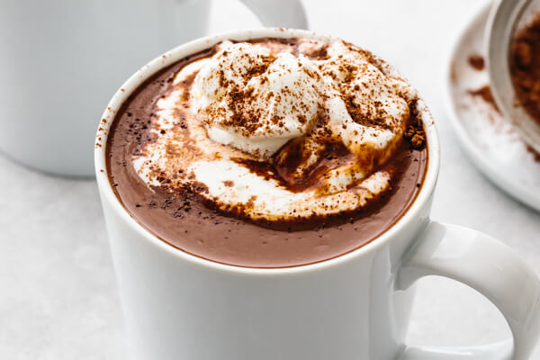 A whit mug with hot chocolate and whipped cream.