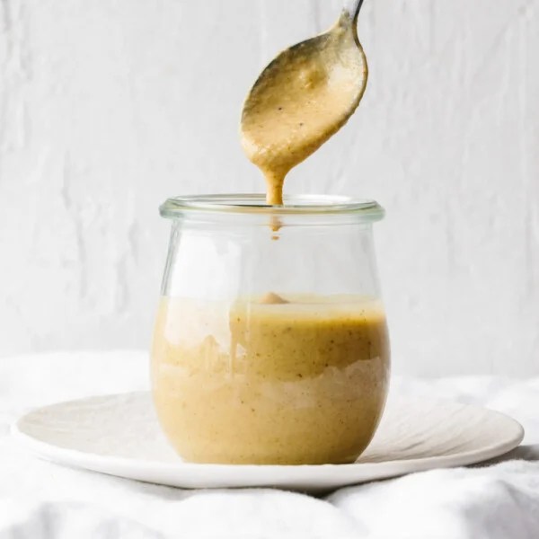 A glass jar of maple mustard tahini dressing