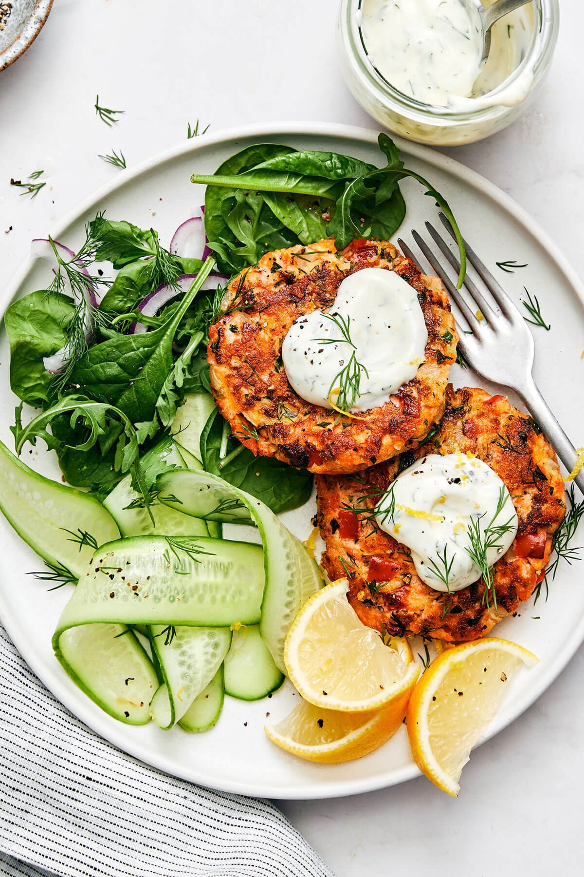 Salmon patties with a side salad on a plate.