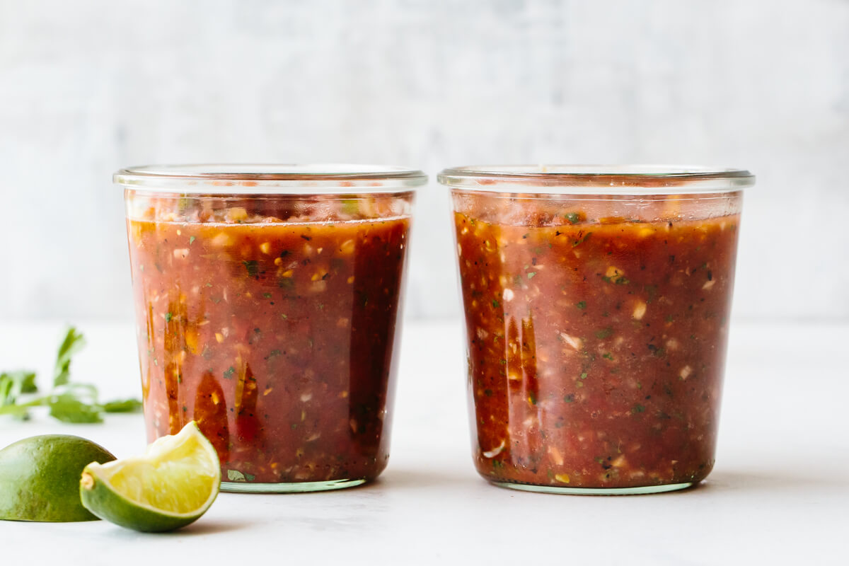 Two glass jars of salsa ready to be stored.