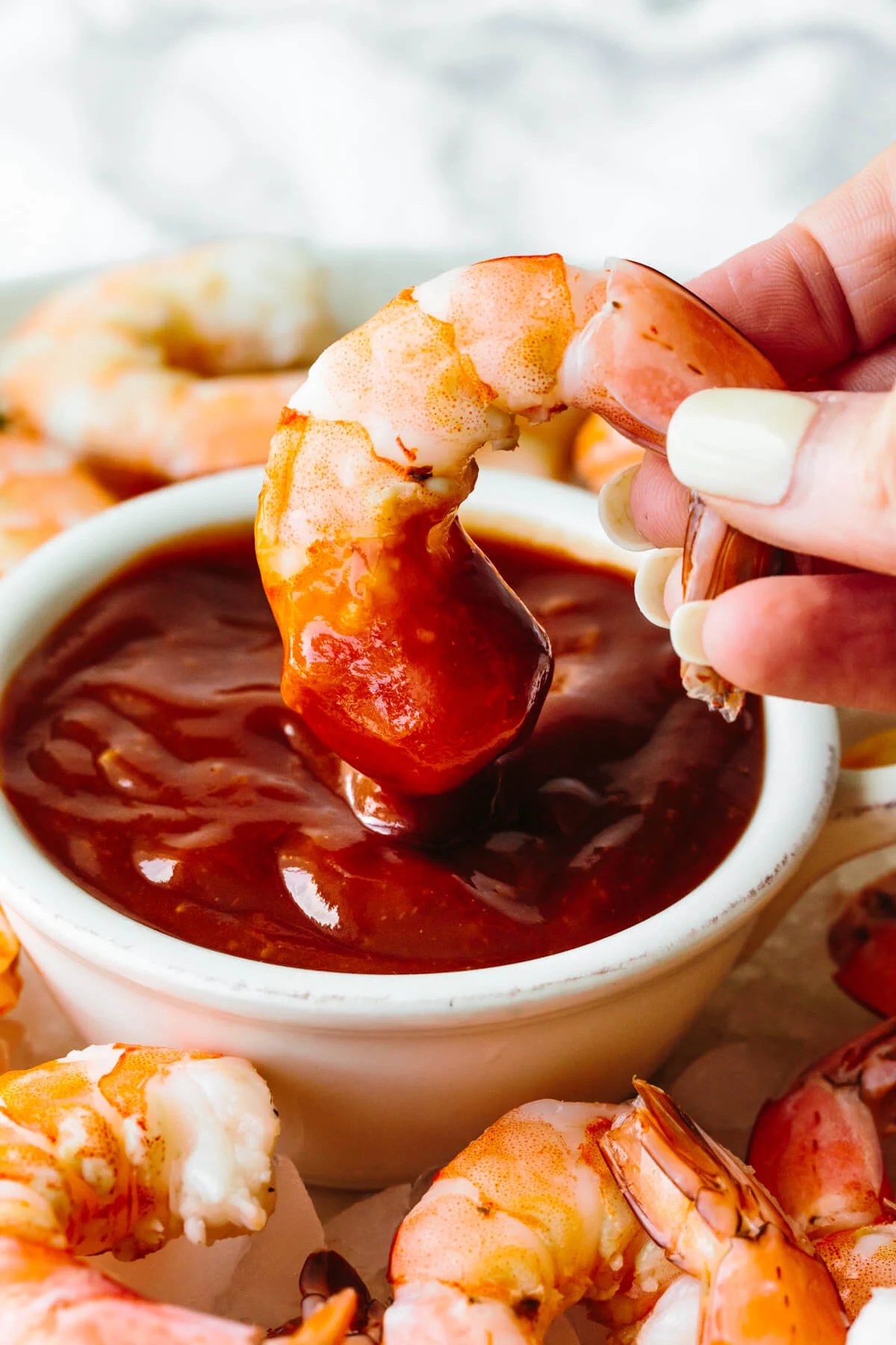 Dipping shrimp into cocktail sauce