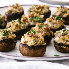 Stuffed mushrooms filling up a white plate.