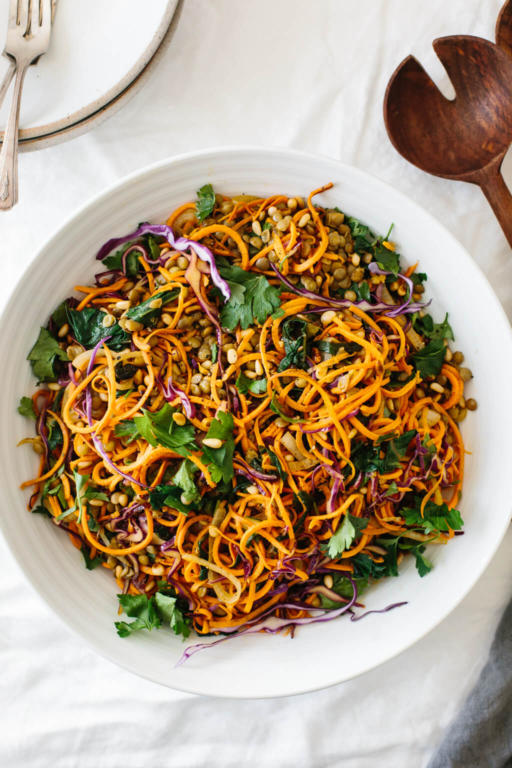 Sweet potato noodles salad is a combination of spiralized sweet potato noodles, cabbage, lentils, sautéed onions and Swiss chard. It's topped off with fresh herbs, toasted pine nuts and a zesty Dijon vinaigrette.